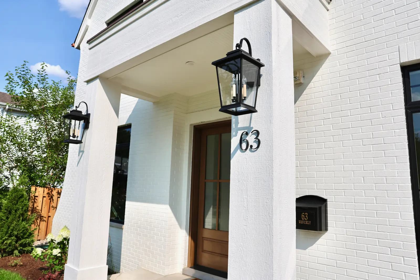 Wood front door, lanterns, and address detail at 63 Waverly